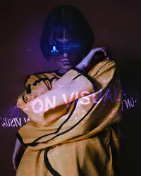 A futuristic woman in a yellow jacket and Atari visor, surrounded by digital text.