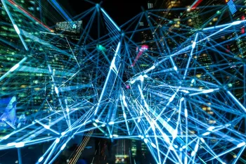 A complex network of glowing blue lines representing digital connectivity is superimposed over a modern city at night.